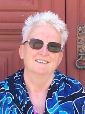 Picture of photographer (Penny) smiling, with short spiked white hair and sunglasses